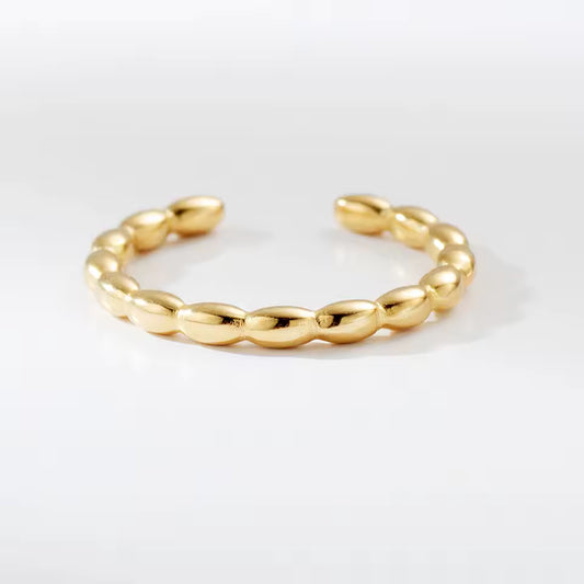 Gold ring with a textured band on a white background