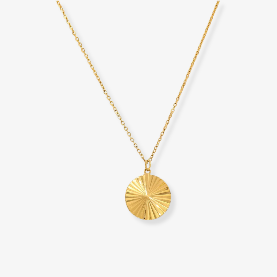 Gold necklace with a round pendant on a white background