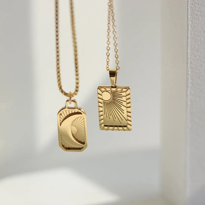 Two gold necklaces with geometric pendants on a light background